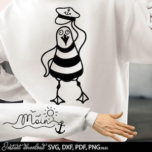 May include: White sweatshirt featuring a black and white cartoon seagull wearing a sailor hat with an anchor. The sleeve displays the word "Main" with a sun, waves, and an anchor. The bottom of the image says "Instant download SVG, DXF, PDF, PNG FILES."