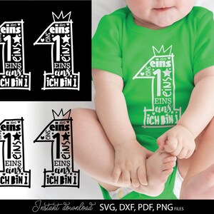 Schwarzes typografisches Design mit der Zahl 1 in kreativer Schriftgestaltung und kleinen Sternen sowie Herzsymbolen, kombiniert mit dem Text „Ich bin 1“ und mehrfach wiederholtem Wort „eins“. Das Motiv ist auf einem hellblauen Babybody dargestellt und zusätzlich in verschiedenen Farbvarianten als Grafik gezeigt. Perfekt geeignet für den ersten Geburtstag eines Kindes, für DIY Projekte wie Kleidung, Deko oder personalisierte Geschenke zur Feier des ersten Lebensjahres.