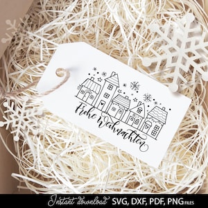 Geschenkbox mit Anhänger, auf dem eine Häuserreihe mit Schriftzug „Frohe Weihnachten“ abgebildet ist. Der Geschenkanhänger ist mit Schneeflocken dekoriert und passt ideal zu Weihnachtsgeschenken, Adventsüberraschungen oder als Dekoration. Dieses Design vermittelt festliche Freude und eignet sich hervorragend für Bastelprojekte, Geschenkideen und kreative Dekorationen zur Weihnachtszeit.
