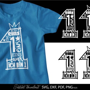 Schwarzes typografisches Design mit der Zahl 1 in kreativer Schriftgestaltung und kleinen Sternen sowie Herzsymbolen, kombiniert mit dem Text „Ich bin 1“ und mehrfach wiederholtem Wort „eins“. Das Motiv ist auf einem hellblauen Babybody dargestellt und zusätzlich in verschiedenen Farbvarianten als Grafik gezeigt. Perfekt geeignet für den ersten Geburtstag eines Kindes, für DIY Projekte wie Kleidung, Deko oder personalisierte Geschenke zur Feier des ersten Lebensjahres.