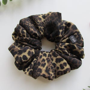 May include: A brown and tan leopard print scrunchie with a black tag that says "STAR".