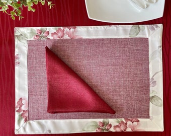Set van vlekbestendige placemats met bloemenprint in linnenlook. Vlekbestendige bordeauxrode placemats met bloemenprint voor het ontbijt.