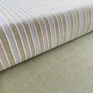 Stoffa di alta qualità in policotone con righe eleganti e tinta unita verde, ideale per rivestire poltrone e realizzare complementi d’arredo.
