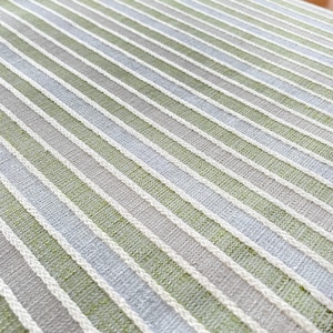 Tessuto a righe verde-beige-grigio in policotone, perfetto per progetti creativi e lavori di sartoria come tovaglie e borse.