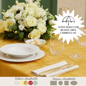 Può includere: Un'apparecchiatura formale per la tavola da pranzo con una tovaglia gialla, piatti bianchi, posate dorate e bicchieri trasparenti con bordi dorati. Sullo sfondo c'è una composizione floreale di rose bianche e verde. Il testo dice "WITH HOLE FOR REMOVABLE UMBRELLAS!"