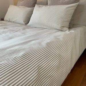Puede incluir: Un juego de cama a rayas blancas y grises con una funda n&oacute;rdica y dos fundas de almohada.