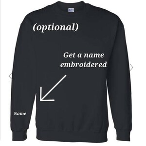 May include: Black sweatshirt with the text "(optional)" and "Get a name embroidered" on the front. An arrow points to the area where a name can be embroidered on the left sleeve.