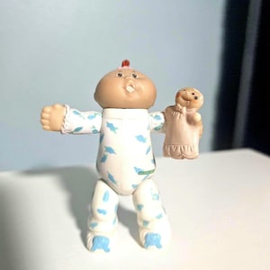 Puede incluir: Un juego de tres tazas de cerámica con un acabado mate moteado. Las tazas son de color crema, gris claro y gris oscuro. Cada taza tiene un diseño simple y minimalista, perfecto para café o té.