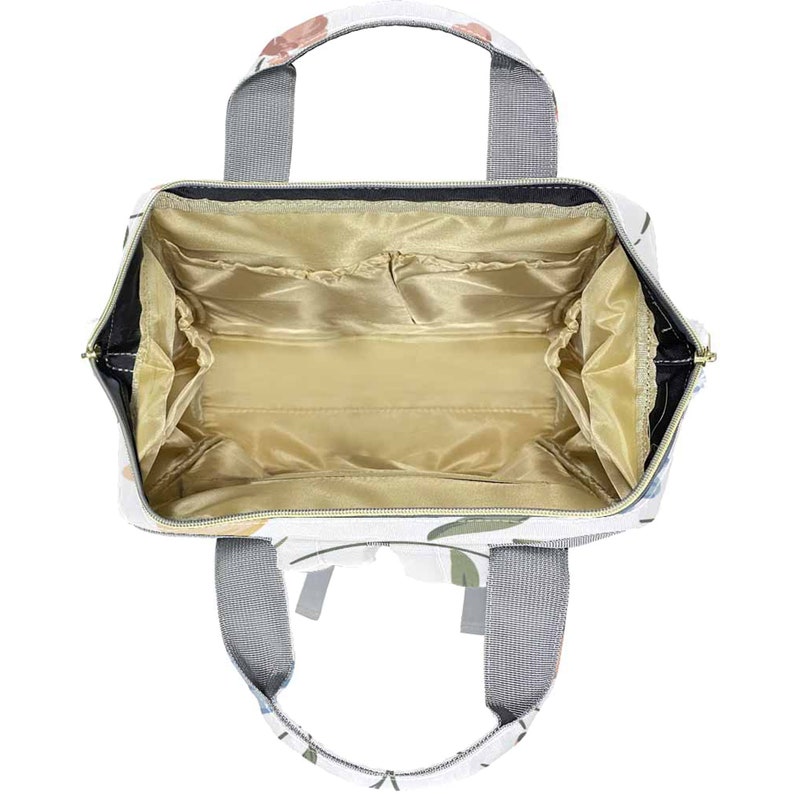 May include: An open white canvas tote bag with a floral print. The bag has a zipper closure and multiple interior pockets. The bag has two top handles and two adjustable shoulder straps.