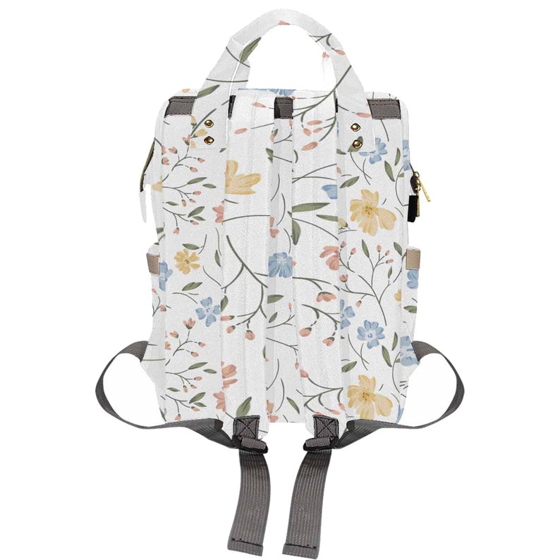 May include: A white floral print diaper bag backpack with gray straps. The bag has a top handle and a zipper closure.