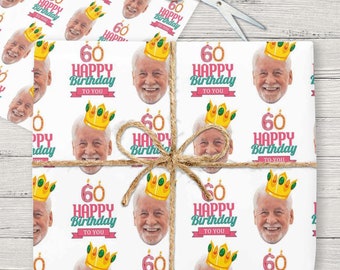 May include: White wrapping paper with a repeated pattern of a man's face wearing a gold crown and the text "60 Happy Birthday To You".