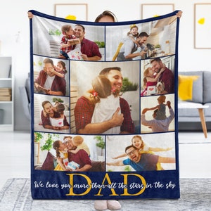 May include: A navy blue fleece blanket with a collage of photos of a father and his children. The photos are arranged in a grid pattern and show the father interacting with his children in various settings. The blanket has a gold inscription at the bottom that reads "We love you more than all the stars in the sky DAD".