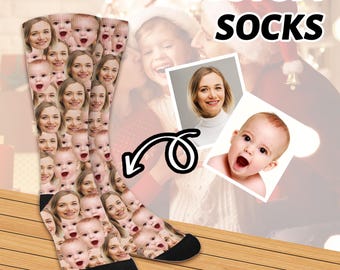 May include: A pair of white socks with a custom design featuring multiple faces. The socks are shown on a wooden surface with the text "CUSTOM SOCKS" above them.