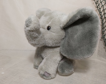 May include: A gray plush elephant toy with large floppy ears. The elephant has a soft, fuzzy texture and a sweet expression.