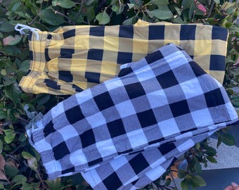 May include: Two pairs of plaid pajama pants. One pair is yellow and black, the other is white and black.