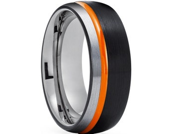 May include: A black and silver tungsten carbide ring with an orange stripe. The ring has a brushed finish and a beveled edge.