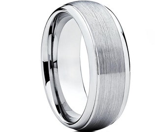 May include: A silver tungsten carbide wedding band with a brushed finish and a beveled edge.