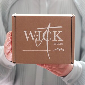 May include: A brown cardboard box with the text "WICK STUDIO" printed in white on the front.