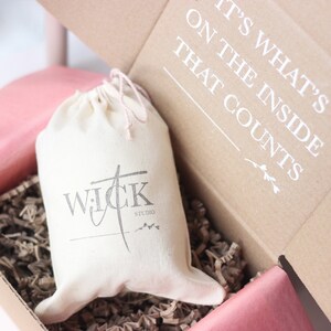 May include: A white canvas bag with a black logo that says "WICK STUDIO" inside a brown cardboard box with the text "IT'S WHAT'S ON THE INSIDE THAT COUNTS".