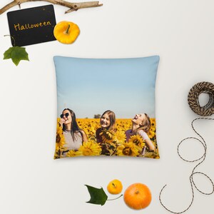 May include: Three women laughing in a field of sunflowers. The women are wearing casual clothing and sunglasses. The sky is blue and the sunflowers are in full bloom.