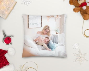 May include: A white throw pillow featuring a printed image of a mother and child laughing on a sofa. The quote "The test of a first-rate intelligence is the ability to hold two opposed ideas in mind at the same time and still retain the ability to function. One should, for example, be able to see that things are hopeless and yet be determined to make them otherwise." by F. Scott Fitzgerald is printed on a sign behind them.