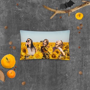 May include: Three women laughing in a field of sunflowers. They are wearing casual clothing and sunglasses. The sunflowers are in full bloom and the sky is blue.