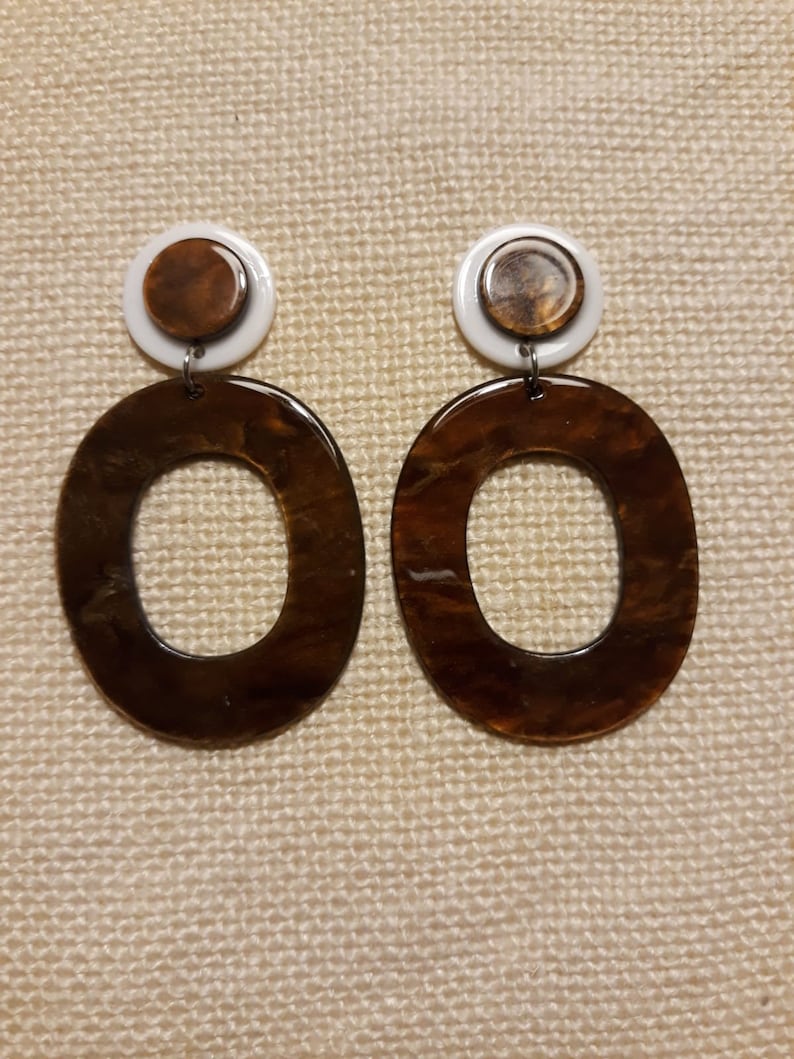 resin earrings dangling in brown and white colors