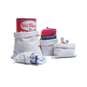 May include: Four white canvas bags with different contents. The largest bag has a red can with the words "Wet Paint" and "Red" on it. The second largest bag has a red and blue wallet. The third bag has a small orange object. The smallest bag has a bundle of colorful markers.