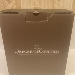 Puede incluir: Una caja de cart&oacute;n marr&oacute;n con un logotipo blanco que dice "Jaeger-LeCoultre".