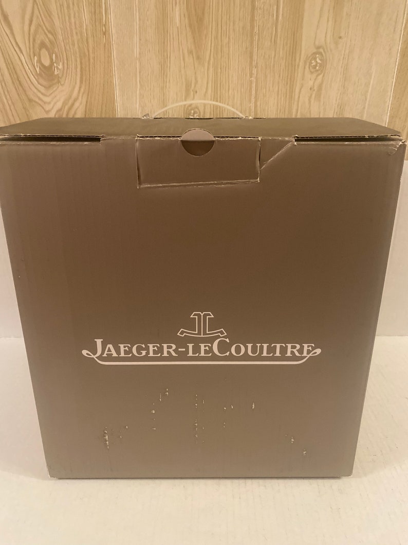 Puede incluir: Una caja de cart&oacute;n marr&oacute;n con un logotipo blanco que dice "Jaeger-LeCoultre".