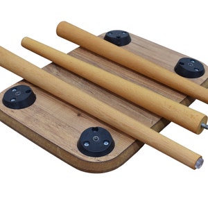 May include: Four wooden table legs with black plastic feet. The legs are laid out on a wooden surface.