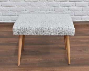 Beautiful modern wooden footstool with soft fabric upholstery, wartanstore