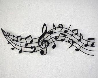 May include: Black metal wall art featuring a treble clef and musical notes in a flowing design.
