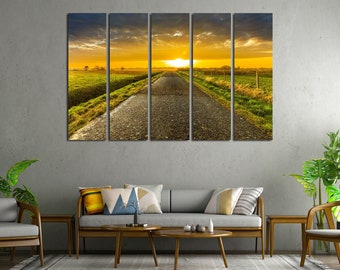 May include: A five-panel canvas print depicting a long, straight road leading towards a sunset over a field. The road is paved and the field is green with a fence along the side.