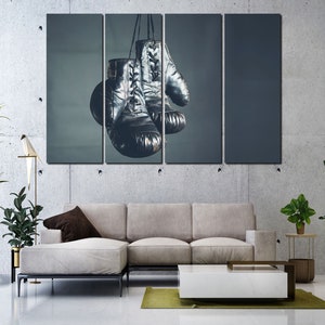 May include: A set of three canvas prints featuring a pair of black leather boxing gloves hanging from a hook. The gloves are against a dark blue background.