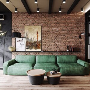 May include: A green sofa with two round coffee tables in front of it. The sofa is in a living room with a brick wall and a neon sign that says "Today is a good day".
