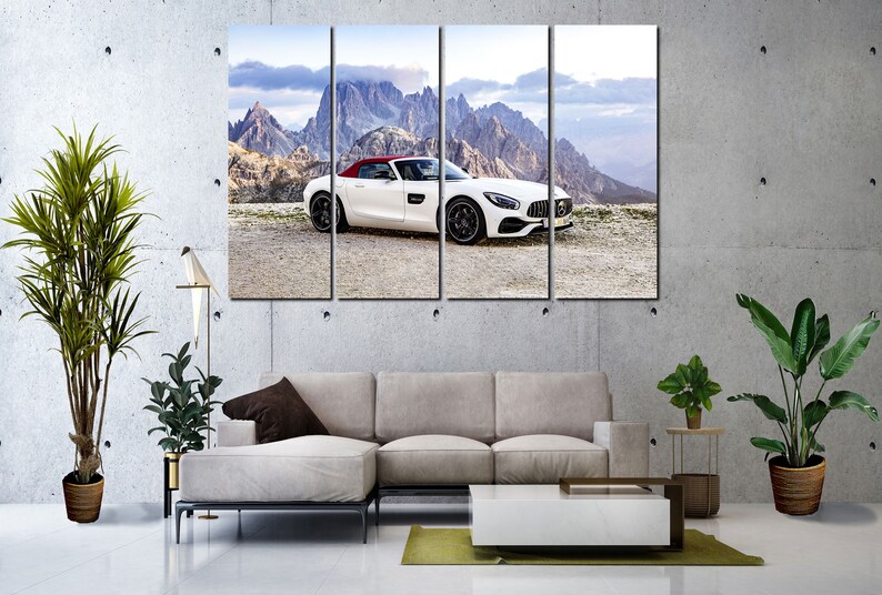 May include: A white convertible sports car with a red roof is parked on a dirt road in front of a mountain range. The car is facing the camera and the mountains are in the background.