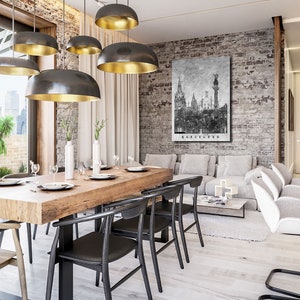 May include: A modern dining room with a wooden table and black chairs. The room has a brick wall with a black and white cityscape print that says "Barcelona". There are several gold and black pendant lights hanging from the ceiling.