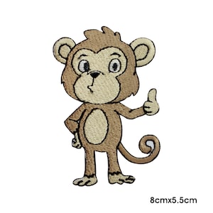 May include: Brown cartoon monkey with a big smile and thumbs up. The monkey is standing on two legs and has a tail. The monkey is 8 cm by 5.5 cm.