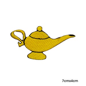 May include: A gold embroidered iron-on patch of a genie lamp, measuring 7 inches by 4 inches.