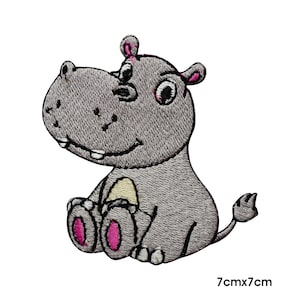 May include: Embroidered patch of a cartoon hippo in gray with pink accents on the ears and feet. The hippo is sitting with a smiling expression. The patch measures 7cm x 7cm.