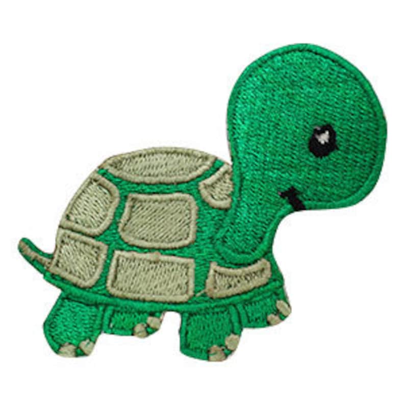 May include: Embroidered green turtle patch with a light green shell pattern. The turtle has a black eye and a smiling mouth. The patch is designed to be ironed on or sewn onto fabric.