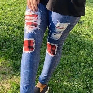 May include: Blue denim leggings with red and black plaid patches and distressed details.