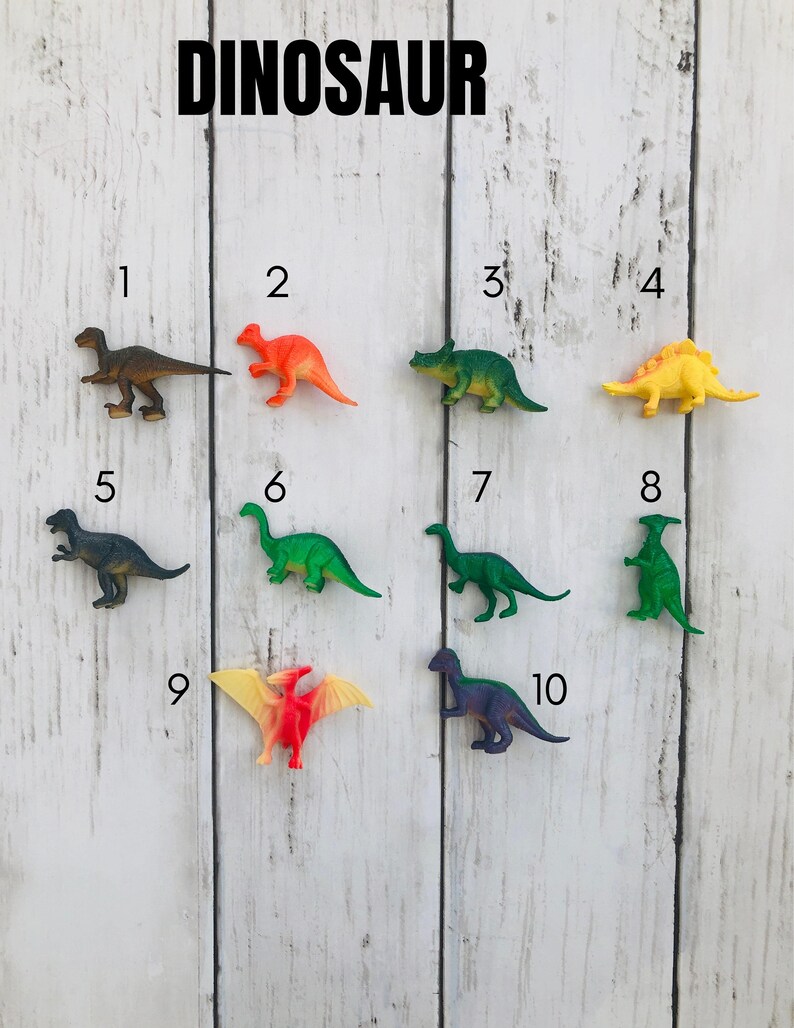 K&ouml;nnte beinhalten: Ein Set aus zehn bunten Plastik-Dinosaurier-Spielzeugen, die von 1 bis 10 nummeriert sind. Die Dinosaurier sind in zwei Reihen auf einem wei&szlig;en Holzgrund angeordnet. Die Dinosaurier sind alle in verschiedenen Farben und Gr&ouml;&szlig;en.
