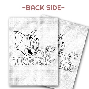 May include: Two white rectangular items with a black and white cartoon graphic of Tom and Jerry. The text "TOM and JERRY" is below the cartoon characters. The background has a textured, off-white appearance.