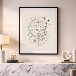 Op de afbeelding: Ingelijste kunstprint met een hemels ontwerp, inclusief een halve maan, sterren en geometrische vormen. Het kunstwerk is in zwart en blauwgroen op een crèmekleurige achtergrond, omlijst door een zwarte rand. Minimalistische, bohemien esthetiek.