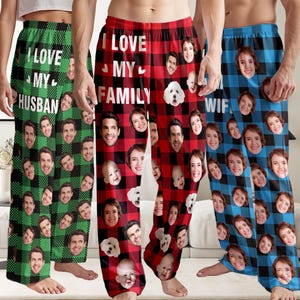 May include: Three pairs of personalized pajama pants with faces printed on them. One pair is green and black plaid with "I LOVE MY HUSBAND" text. Another is red and black plaid with "I LOVE MY FAMILY" text. The third is blue and black plaid with "WIF" text.