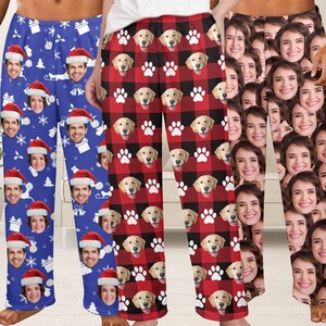 May include: Three pairs of pajama pants with unique patterns. One pair is blue with faces wearing Santa hats and snowflakes. Another is red and black plaid with dog faces and paw prints. The third pair is covered in faces.