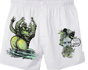 Peut inclure: Boxer blanc avec un imprimé graphique vert et noir d'un monstre tenant une planche de surf. Le texte "Release the Kraken" est dans une bulle de dialogue au-dessus du monstre. Le texte "Add your own face" est dans un éclat d'étoile rouge.