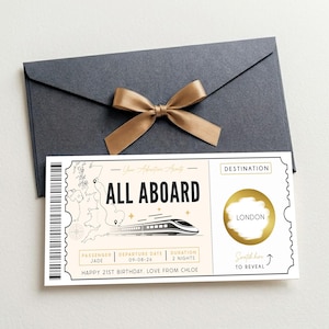 Peut inclure: Une enveloppe gris foncé avec un nœud en ruban doré et un billet à gratter rectangulaire présentant un graphique de train, une carte du Royaume-Uni, le texte ALL ABOARD, et des champs pour le nom, la date, la durée et une destination cachée LONDON.